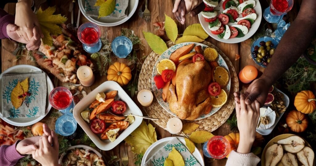 Vegan Thanksgiving feast table with roasted plant-based dishes, colorful salads, and festive decorations, featuring hands holding and sharing gratitude.